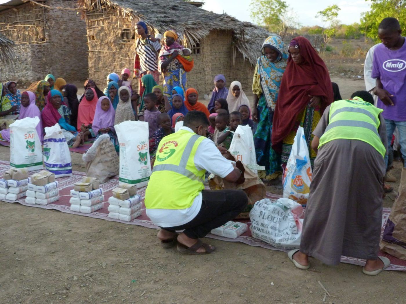 Helping Hands volunteers handing out flour and food parcels to families in a rural village